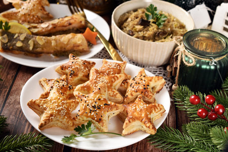 Star shaped puff pastry pies with mushroom filling and sesame topping, fried carp and sauerkraut with mushrooms for Christmas Eve's supper in Polandの写真素材