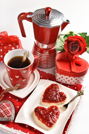 Valentine's coffee and heart shaped toasts with raspberry jam on the table with red napkinの写真素材