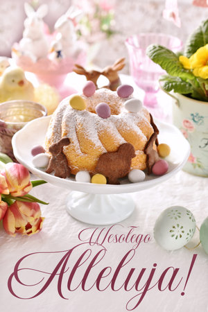 Easter greeting card in pastel colors with traditional ring cake on festive table with inscription in Polish translated as Happy Easterの写真素材