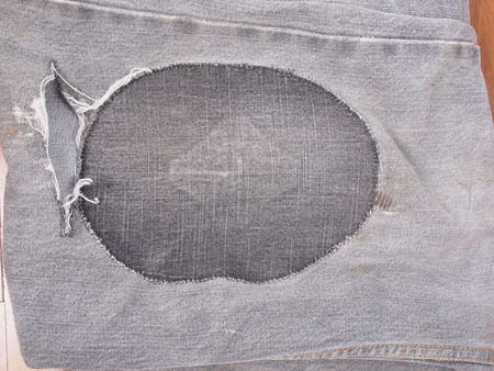 Old torn grunge vintage denim jeans trousersの写真素材