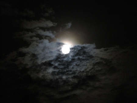 Beautiful bright Full Moon among clouds in the dark sky night.の写真素材