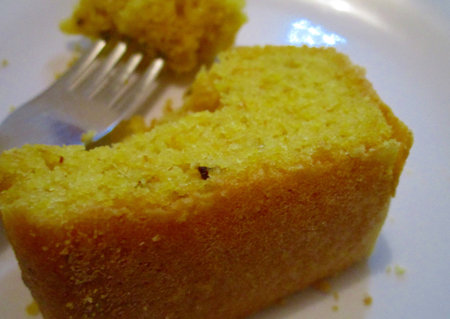 A slice of cake on a plate with a fork in the backgroundの素材