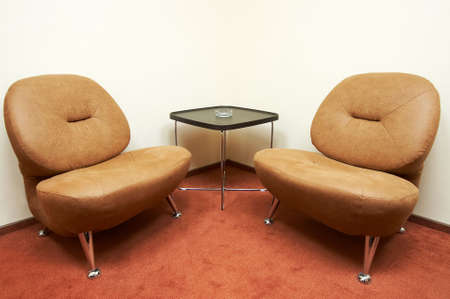 Two leather armchairs and ashtray on a tableの写真素材