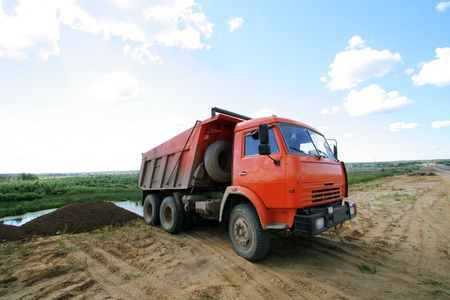 Red dumper on a under construction roadの写真素材