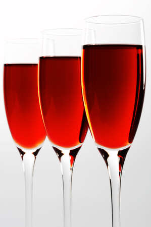 Three high and beautiful glasses with red wineの写真素材