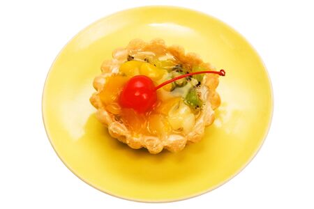 Cake with a cherry on a yellow plateの写真素材