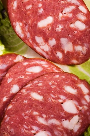 Fresh sausage on a leaf of green salad