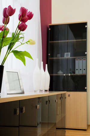 Artificial flowers at a window at officeの写真素材