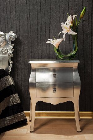 bouquet of lilies on the bedside table in a modern bedroomの写真素材