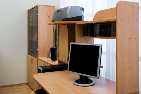 Modern computer on a desk near the windowの写真素材