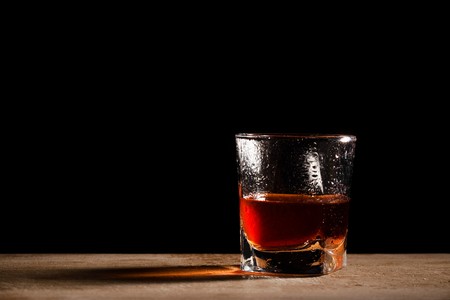 glass from whisky on a wooden tableの写真素材