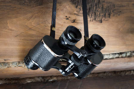 an old pair of binoculars on a wooden wallの写真素材