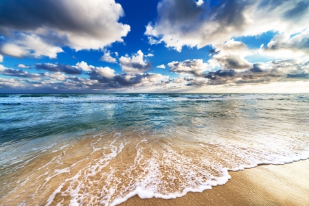beautiful yellow sandy beach at sunriseの写真素材