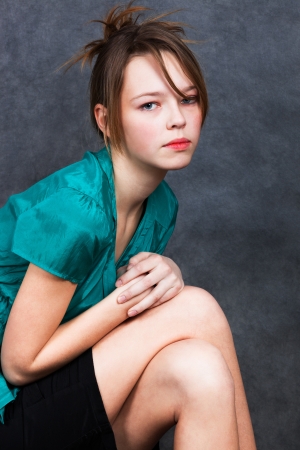 girl in turquoise blouse with a gray backgroundの写真素材