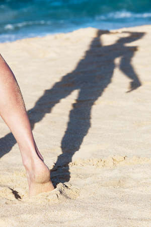 shadow of a girl on the sandy beachの写真素材