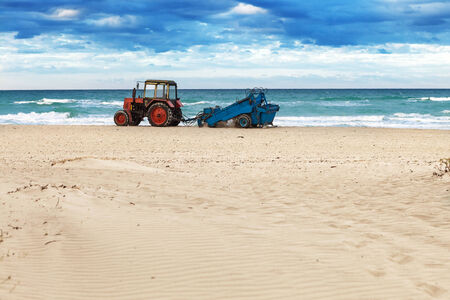 tractor on the sandy beach cleaningの写真素材