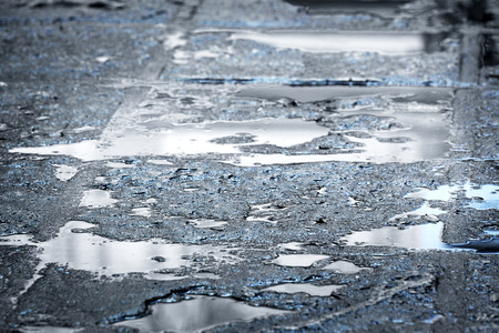 rain puddles on a pavement in the city
