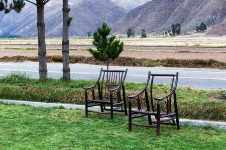 two wooden chairs near the highwayの写真素材