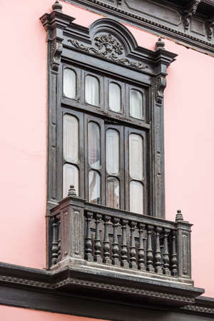 wooden balcony and a window on pink buildingの写真素材
