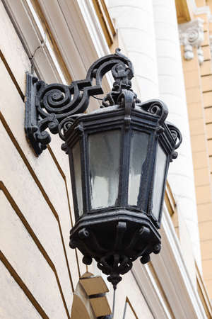 old street lamp on the wall of yellow houseの写真素材