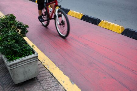 cyclist on a red bike path in modern cityの写真素材