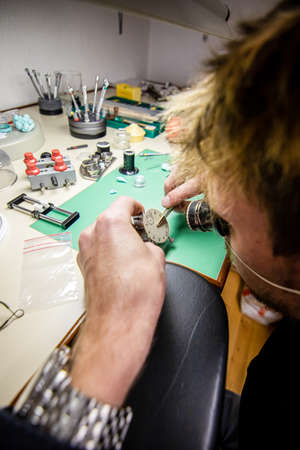 Watchmaker. Watch repair craftsman repairing watch. mans hands
