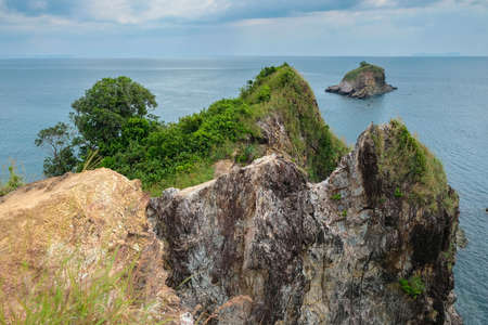 A rock in the sea covered with vegetation. Koh Lanta, Thailandの写真素材