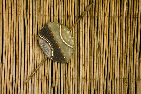 African Warrior Shield hanging on a wooden hut.の写真素材