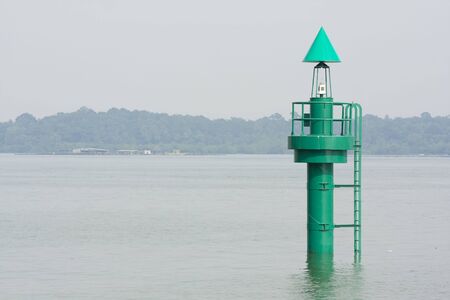 A green buoy in the ocean marking shipping lanesの写真素材