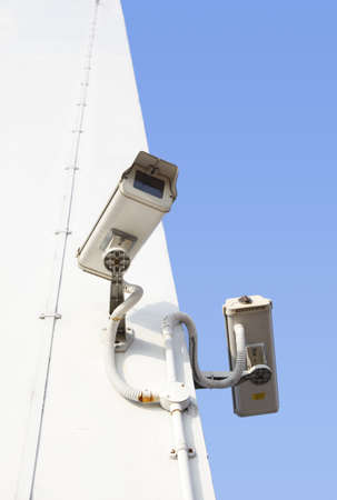 Two security cameras mounted on concrete wallの写真素材