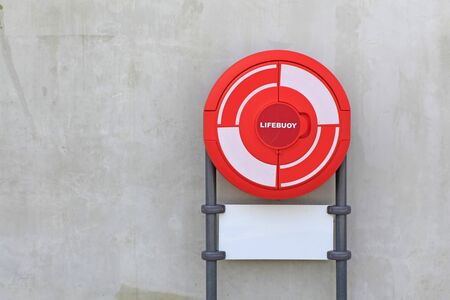 Red Life Buoy attached to a concrete wallの写真素材