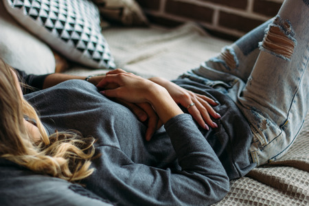 Beautiful woman lying on the bed. Cropped image.の写真素材
