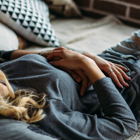 Beautiful woman lying on the bed. Cropped image.の写真素材