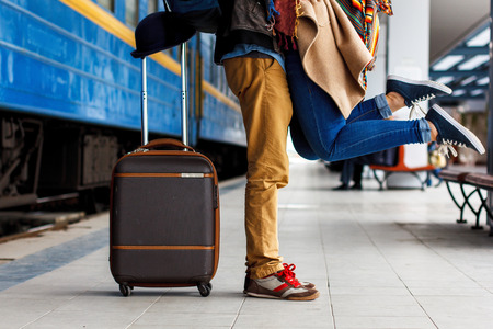 Happy moment of couple love, man in love lifting hi girlfriend in a hug,relaxing front of the urban background,concept about relationship, and travel couple concept. Brown luggageの写真素材