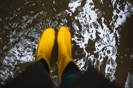 Yellow rubber boots in the water. Top view