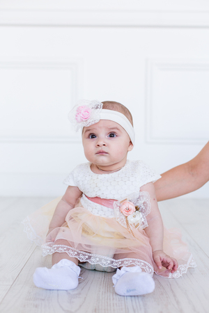 Beautiful baby girl smiling happily. Pink panths and white shirt. 6 months old girlの写真素材