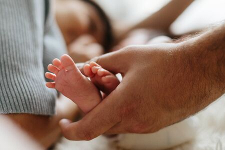 Parent holding in the hands feet of newborn baby.の写真素材