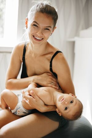 Happy family laughing faces, mother holding adorable child baby boy, smiling and hugging, close up...