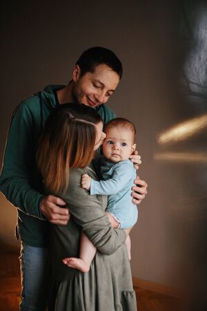 Portrait of a young happy family with the kid. Beautiful family hugsの写真素材