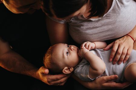 Happy young family with a baby. Parents fun laughing and hugging their child.の写真素材