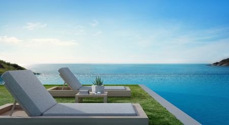 Sea view swimming pool beside terrace and beds in modern luxury beach house with blue sky background, Lounge chairs on green grass at vacation home or hotel - 3d illustration of tourist resortの写真素材