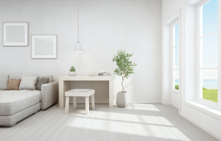 Sea view living room and small working area of modern luxury beach house. Wooden desk with sofa near white window in vacation home or holiday villa. Interior 3d illustrationの写真素材