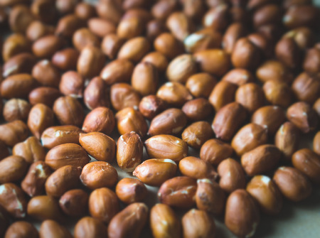 Close up to many peanuts. Bunch of nuts. Group of groundnuts. Shallow depth of field and old retro vintage filter color.の写真素材