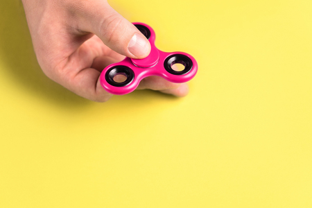 Fidget spinner in hand. Colorful trend toy concept with copy space.の写真素材