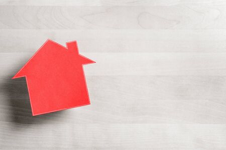 Real estate business. House for sale. Cottage made from cardboard paper on wooden table. House warming party template. Selling and buying home. Empty blank negative copy space.の写真素材