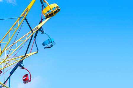 Amusement park background template with negative copy space. Colorful theme park ride against clear blue sky in summer.の写真素材