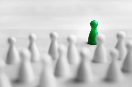 Leadership and management concept. Boss, chief or executive in front of crowd or group. Public speaking and giving presentation. Board game pawns on wooden table.の写真素材
