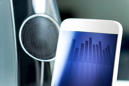 Music streaming with modern portable and wireless smart speaker. Mobile sound application on smartphone screen.の写真素材