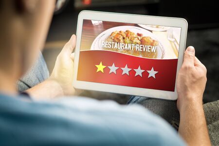 Bad restaurant review. Disappointed and dissatisfied customer giving terrible rating with tablet on...