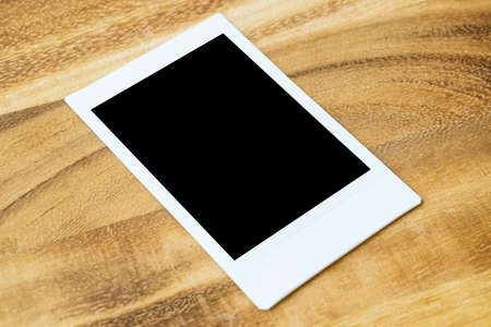 Instant photo frame on wooden table. Empty blank space for picture.の写真素材